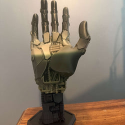3D-printed robot hand controller stand with detailed mechanical joints and sleek metallic finish for gaming desks