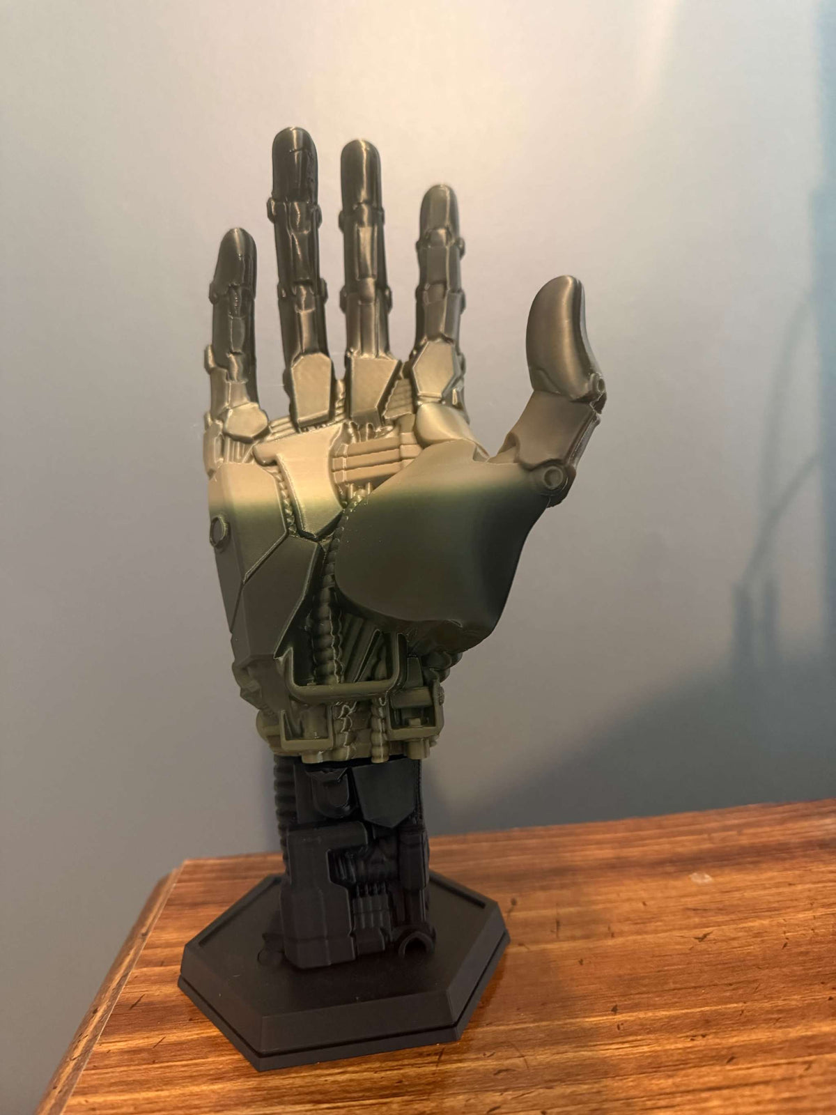 3D-printed robot hand controller stand with detailed mechanical joints and sleek metallic finish for gaming desks