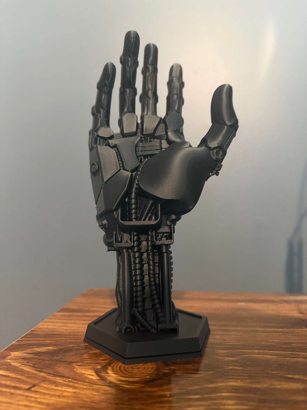 3D-printed robot hand controller stand with detailed mechanical joints and sleek metallic finish for gaming setups