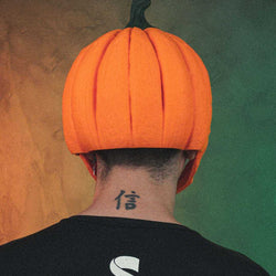 Pumpkin Head Mask in bright orange with a dark green stem and sculpted vertical pumpkin ridges, worn over the head