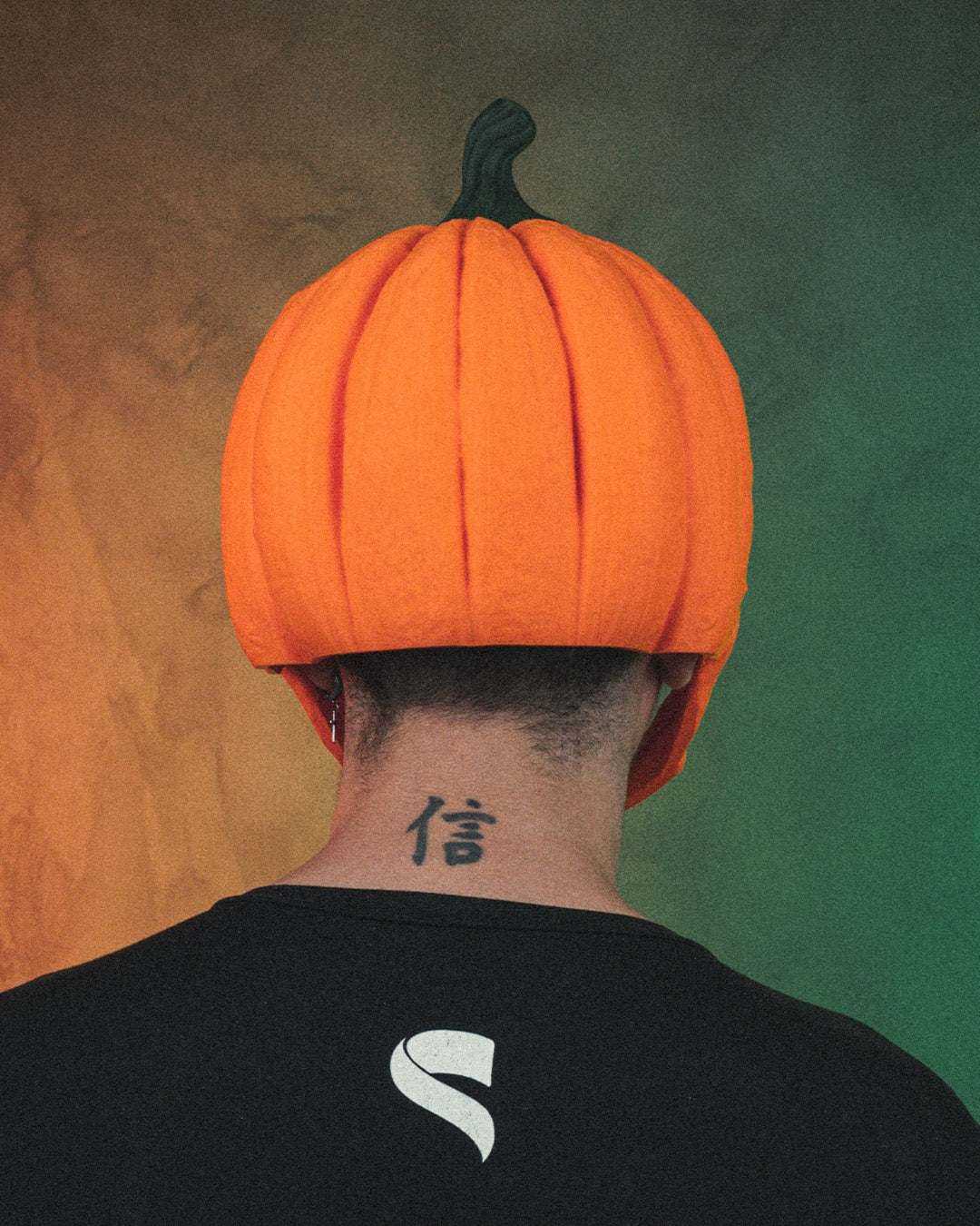 Pumpkin Head Mask in bright orange with a dark green stem and sculpted vertical pumpkin ridges, worn over the head